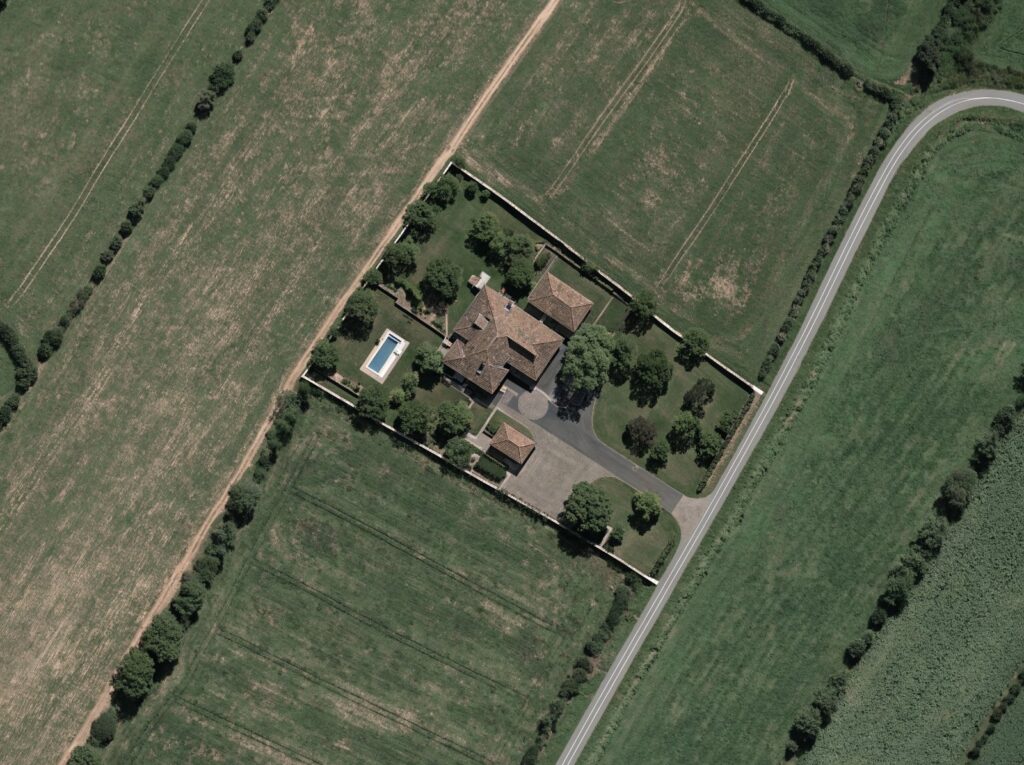 Veduta aerea di una tenuta privata di campagna cintata, con ingresso carrabile dotato di cancello e terreni agricoli circostanti
