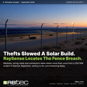 Illustrative image: chain-link and barbed-wire perimeter fence around a desert solar plant at dusk, with empty racking bays and cable coils inside